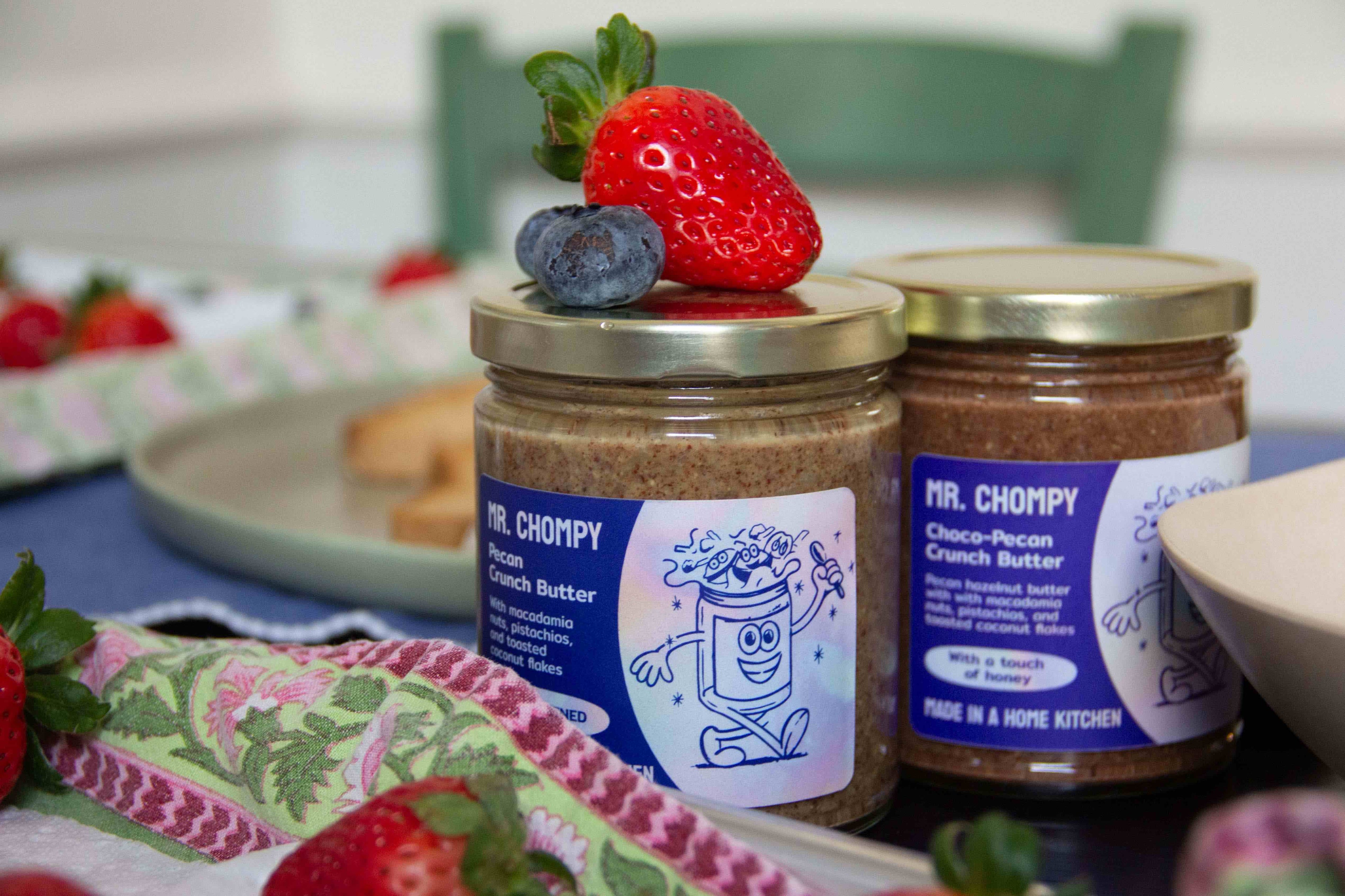 Jars of the pecan butter and chocolate pecan butter on a kitchen table.